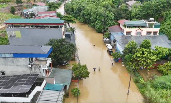 Cảnh sát dầm mình trong nước sâu, đưa người dân khỏi vùng ngập ở Lào Cai